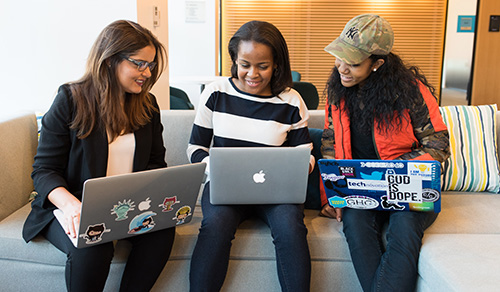 3 female students looking at laptop computers