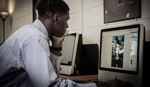 A communications media student works with video-editing software