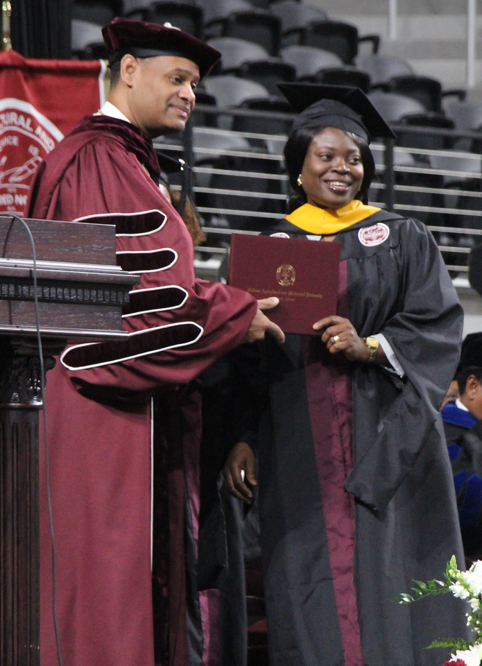 An AAMU graduate receives her diploma at Commencement