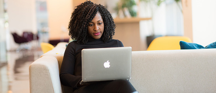 women on couch with laptop