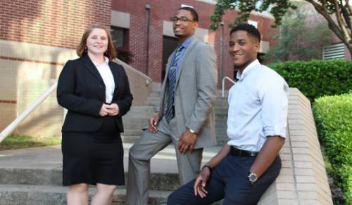 students standing on steps infront of new business school building